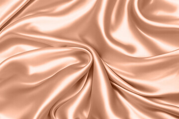 Fototapeta premium Abstract background, folds of silk fabric in peach fuzz color.