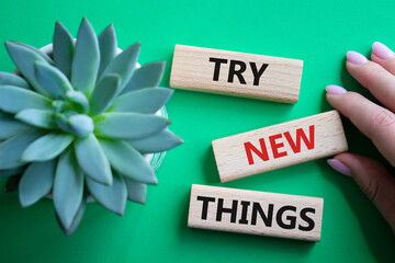 Try new Things symbol. Concept words Try new Things on wooden blocks. Businessman hand. Beautiful...