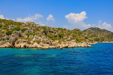 Fototapeta premium View of the rocky shore from the sea. Mediterranean Sea in Turkey. Popular tourist places. Background