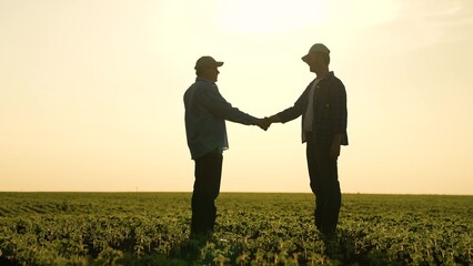 two businessmen farmers shake hands sunset. handshake sign agreement. Agriculture. making a deal...