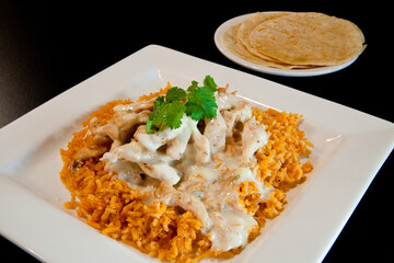 Appetizing Plate of Creamy Arroz con Pollo, Mexican Dish with Queso and Chicken with Tortillas