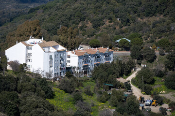 Aerial view of a secluded hotel nestled in a lush, green mountainous area.