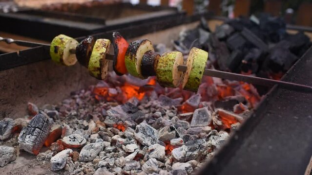 vegetables, zucchini, peppers, tomatoes are fried, cooked on a skewer on the grill.
