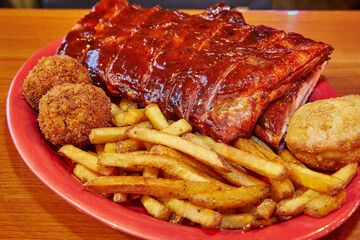 American Barbecue Platter with Pork Ribs and Sides on Red Plate