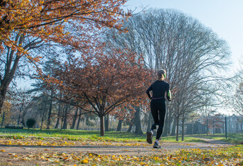Fototapeta premium Girl running in the park to maintain fitness