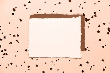 Peach fuzz is color of year 2024. A blank sheet of paper and a red envelope on a pink glitter...