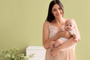 Happy mother with cute little baby in room at home