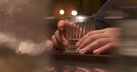 Man drinking alcohol at the bar. Alcohol addiction problem. Close-up glass of whiskey. Selective focus