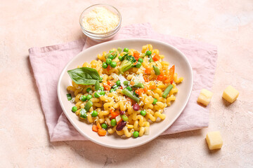 Plate with tasty pasta primavera and cheese on beige background