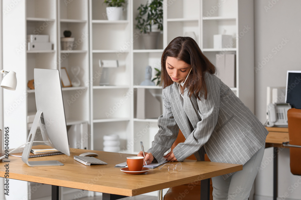 Sticker young businesswoman talking by mobile phone at table in office