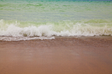 Low View of Turquoise Waves Crashing on Michigan's Reddish Sandy Beach