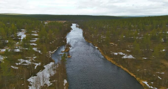 Aerial landscape view of Sotajoki river in cloudy spring weather with snow on the ground, Sodankylä, Lapland,  Finland.