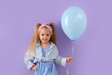 Cute little girl with beautiful balloon on purple background