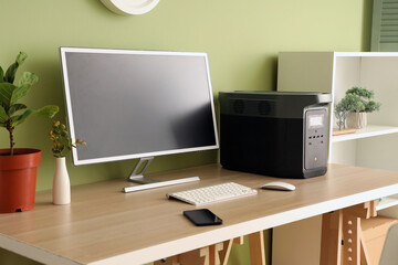 Workplace with computer and portable power station in office