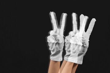 Stroboscopic photo of moving woman showing victory gesture on dark background