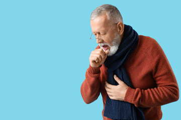 Sick mature man coughing on blue background