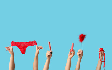 Female hands with different sex toys and panties on color background - obrazy, fototapety, plakaty
