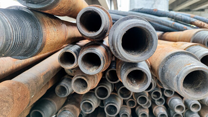 Stacked drill pipe or drill stem, used drilling rusty metal pipes - obrazy, fototapety, plakaty