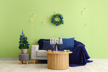 Interior of festive living room with cozy sofa, coffee table and traditional Hanukkah decorations