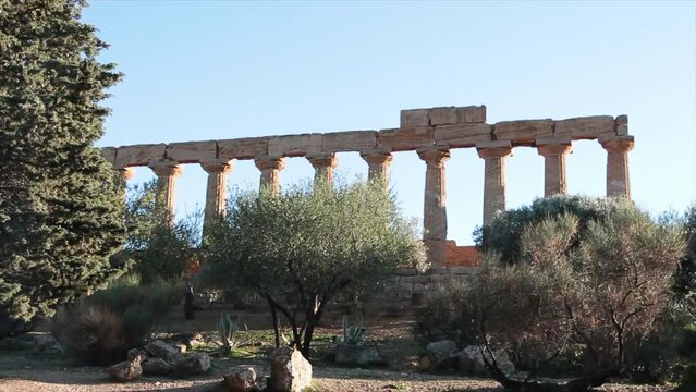 agrigento sicily italy ancient temple of juno pillars with trees in foreground wide shot with zoom in