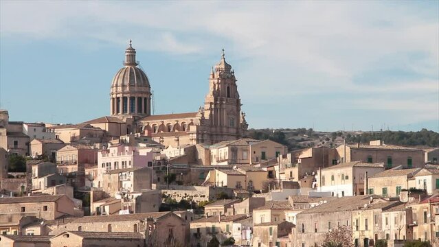 ragusa sicily italy town medium shot church buildings homes houses on hill unlevel uneven ground with sky above