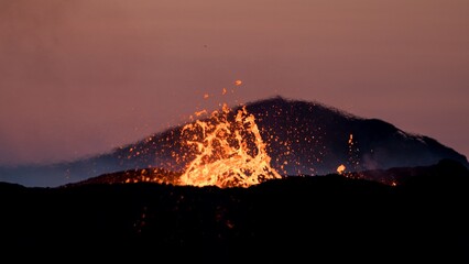 Splashes of hot lava erupting from volcanic crater in Iceland