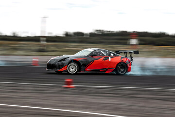 Red Sports Car Drifting Around Racetrack Corner At Speed