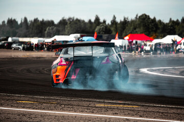 rear view of a drift car in a skid on a corner of a sports car track © AvokadoStudio