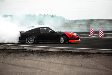 Obraz na płótnie Canvas Adrenaline sport scene car drifting in carpark with lot of smoke from burning tire