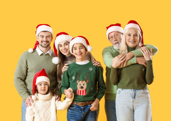 Big family in Santa hats on yellow background