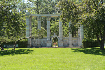 guild guildwood toronto monument pillars with grass and tree in front and bushes wide shot from far...