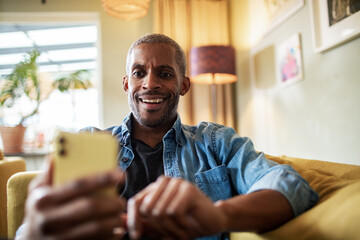Middle aged man using the smartphone at home