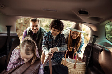 Family taking camping gear out of car