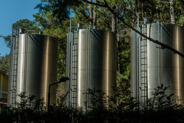 uma industria de envasamento de água mineral, com a imagem dos reservatórios em aço inox, no interior do Brasil, onde se tem as melhores fontes