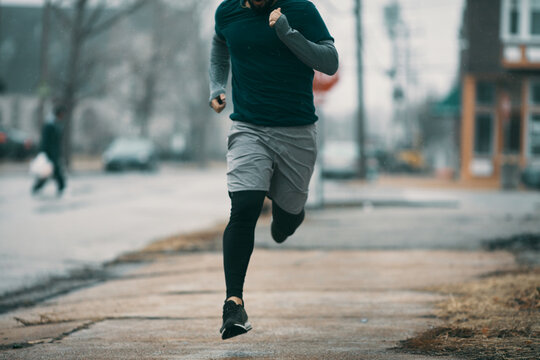 Young man running in rainy weather