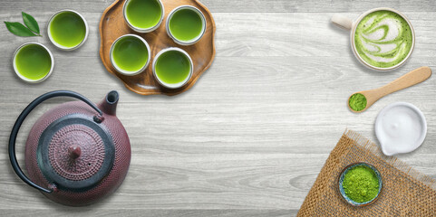 Cups of green tea with cast iron tea pot or kettle and fresh matcha powder                        