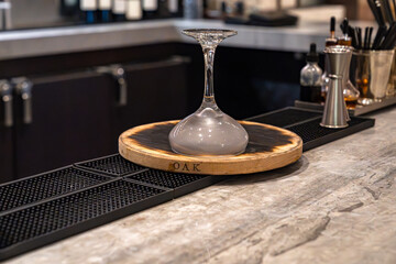 Oak whiskey smoker with upside down cocktail glass in a bar