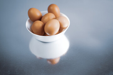 Fresh chicken eggs in white bowl. Close up. 
