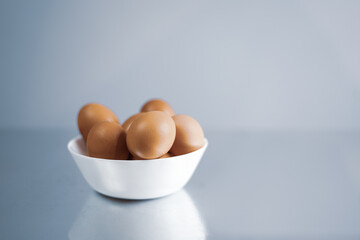 Fresh eggs in a white bowl. 