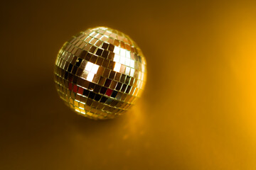 Silver disco ball with a golden background. 