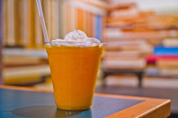 Refreshing Iced Beverage with Whipped Cream in Casual Cafe Setting Close-Up