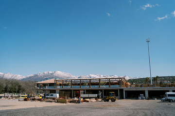Fototapeta na wymiar Trucks stand near a warehouse with boards at the foot of the mountains