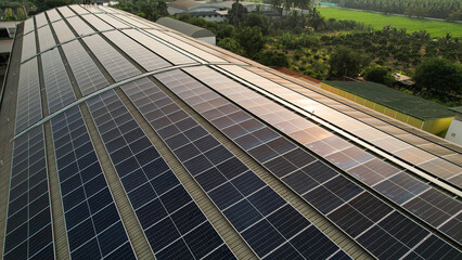 Aerial view of blue photovoltaic solar panels mounted on industrial building roof, ecological electricity. Production of renewable energy