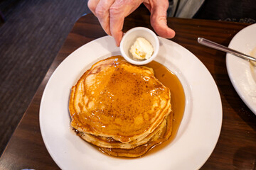 Prince Frederick, Maryland USA A stack of pancakes with a side dish of butter and maple syrup. - obrazy, fototapety, plakaty