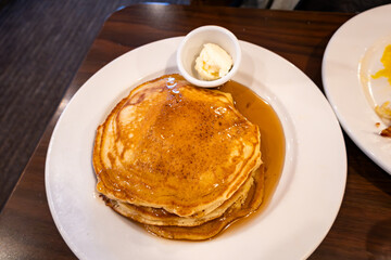 Prince Frederick, Maryland USA A stack of pancakes with a side dish of butter and maple syrup. - obrazy, fototapety, plakaty