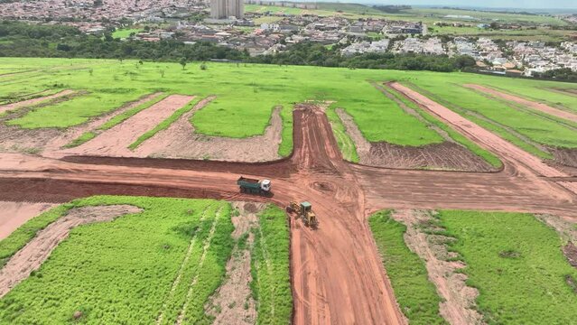 magem a&eacute;rea de canteiro de obras com tratores e caminh&otilde;es construindo loteamentos para um novo bairro na cidade de Paul&iacute;nia, S&atilde;o Paulo.