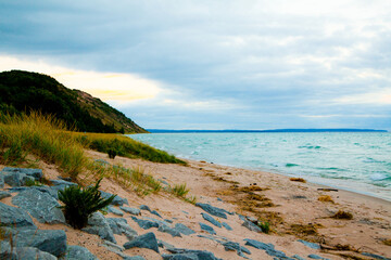 Fototapeta na wymiar Serene Sunrise over Natural Michigan Beach with rocks and grasses