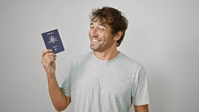 Confident, happy young man joyfully holds his australian passport, smiling against an isolated white background, ready for his next holiday adventure