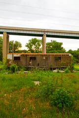 Fototapeta na wymiar Sunset Over Abandoned Urban Building in Illinois with Overgrown Vegetation and Bridge View
