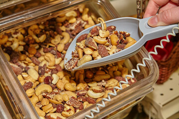 Scoop of Mixed Nuts in Bulk Bin at Health Food Store